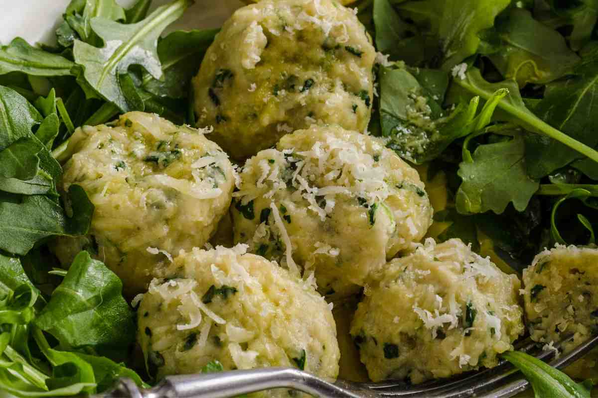 Polpette ricotta e spinaci in un piatto con contorno di rucola