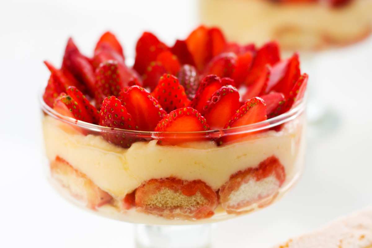 Tiramisù alle fragole in una coppa con savoiardi, crema e tante fragole a fettine