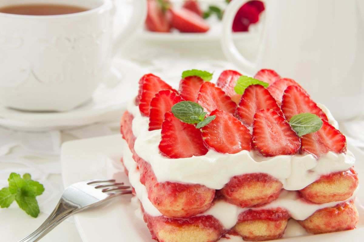 Tiramisù alle fragole adagiato su un piatto e forchetta