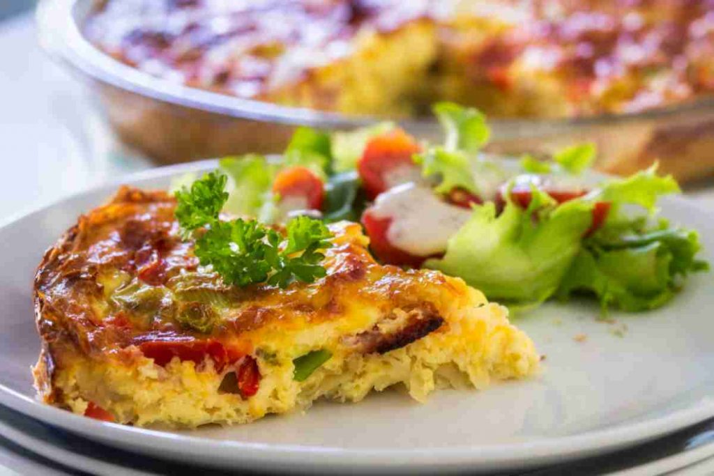 Torta di patate e peperoni in un piatto con contorno di insalatina mista
