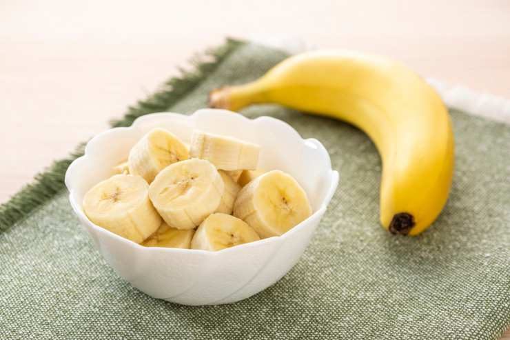 ciotola con pezzi di banana e banana intera accanto