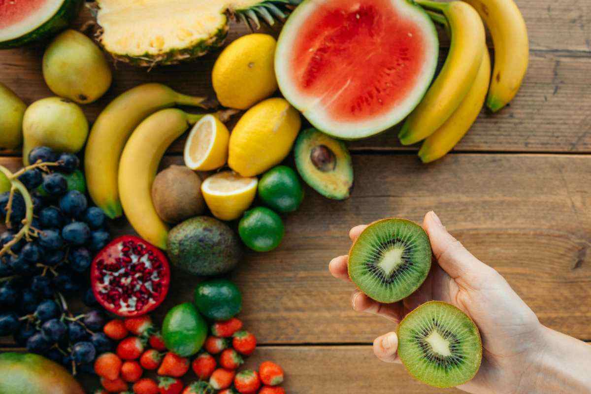 frutta mista e kiwi in mano
