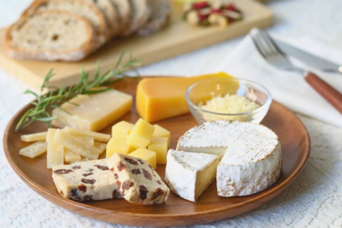 tagliere di legno con sopra diversi formaggi