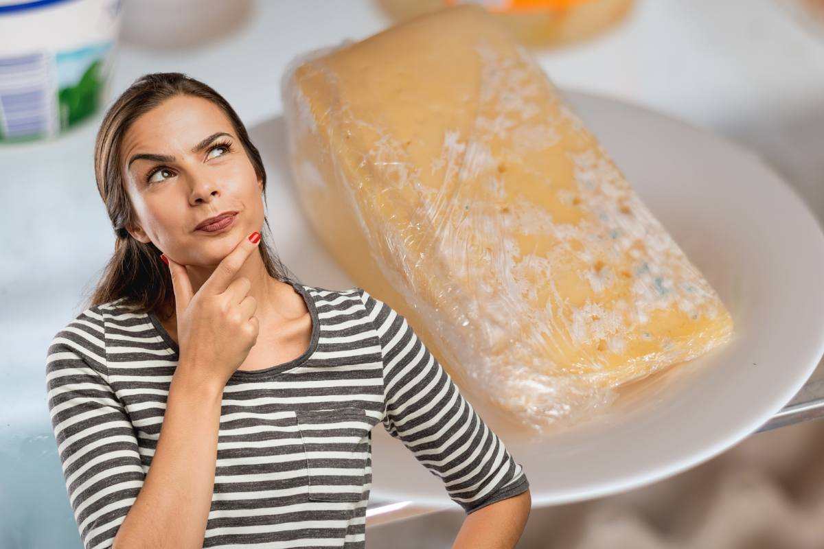 donna pensierosa e pezzo di formaggio