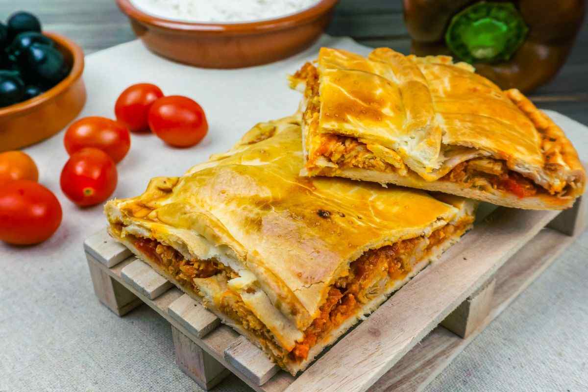 Due grandi fette di torta salata e alcuni ingredienti che si trovano sul tavolo