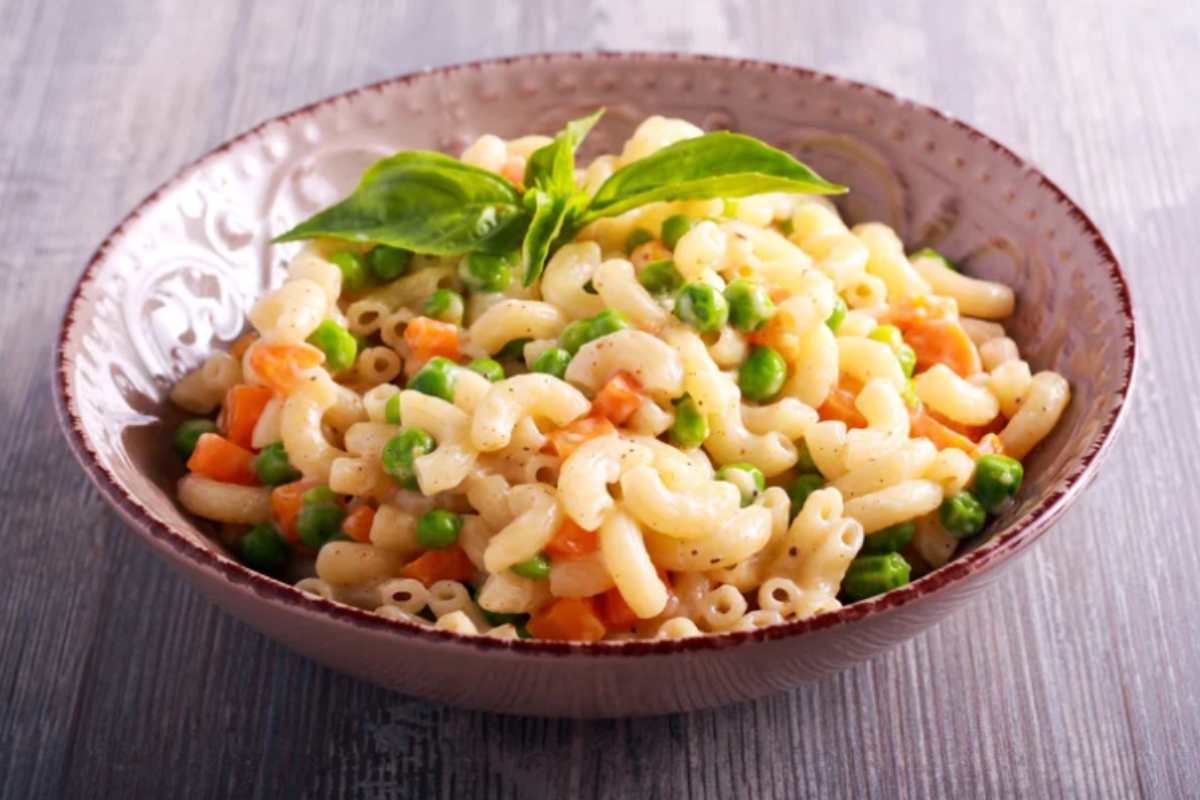 piatto con pasta condita con carote e piselli