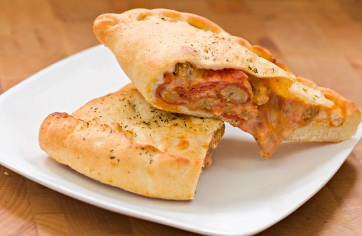 calzone ripieno tagliato a metà in un piatto