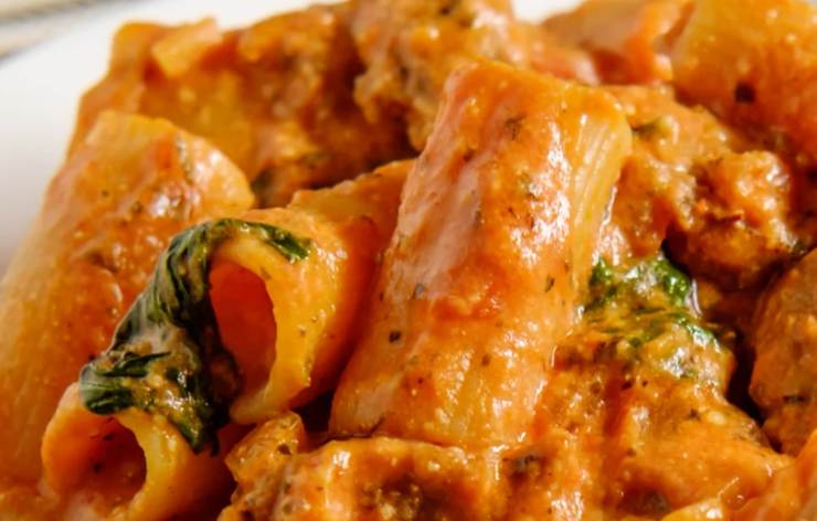 primo piano di maccheroni con sugo di pomodoro e salsicce