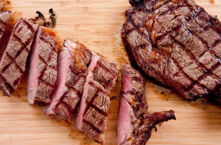 tagliata di carne sopra ad un tagliere di legno