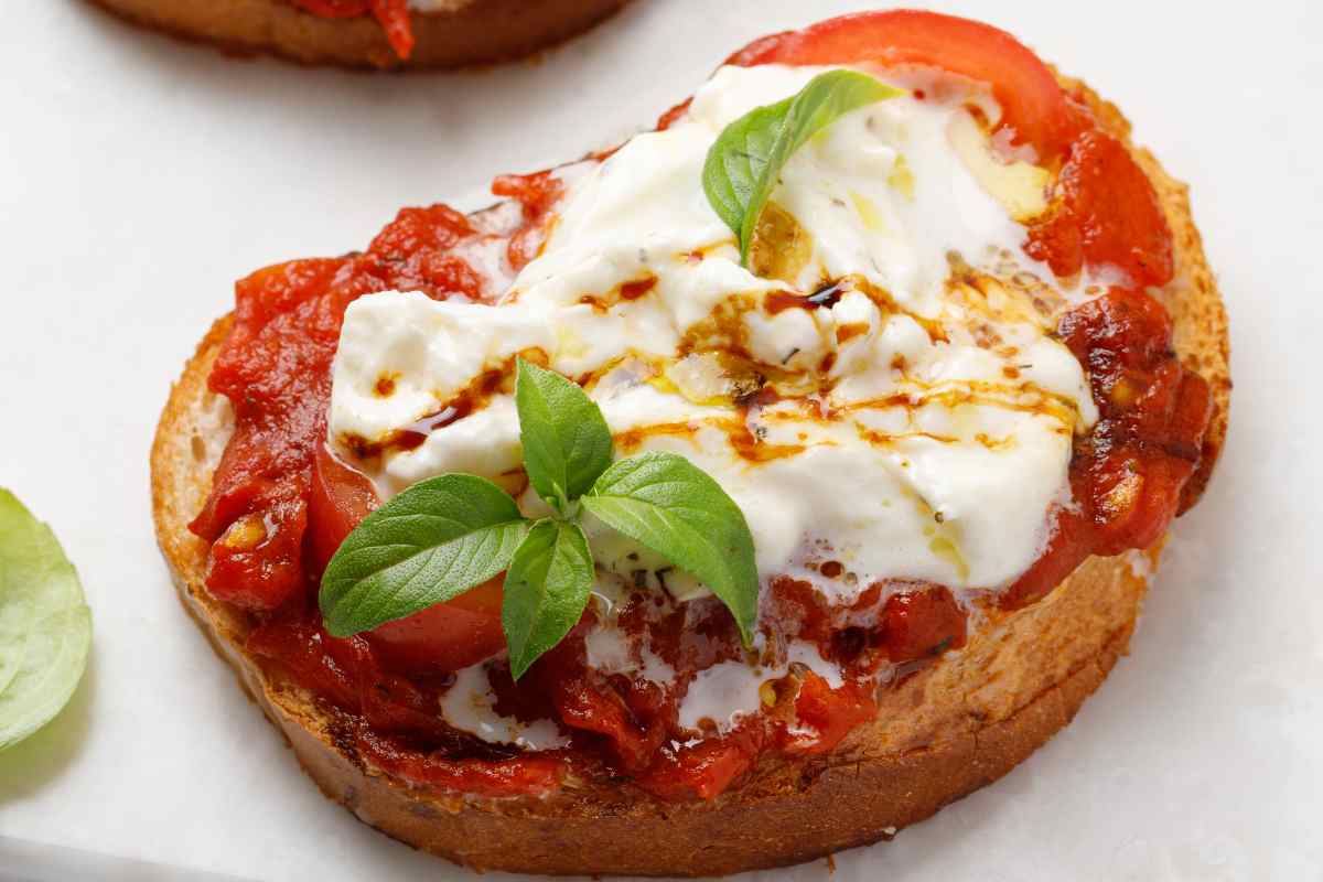 Bruschetta alici pomodoro e stracciatella in un piatto