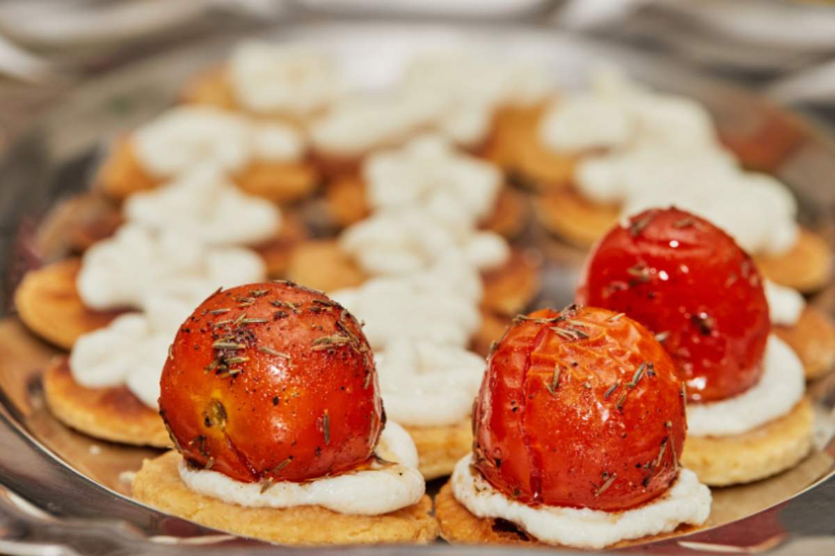 Crackers rotondi con formaggio spalmabile e pomodorini