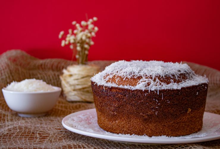 Torta guarnita con cocco rapé in un vassoio su un tavolo