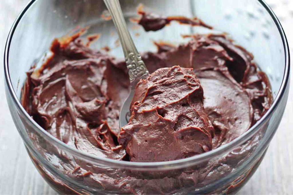 Coppa di cremoso al cioccolato con un cucchiaino dentro