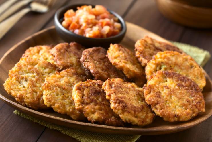 Frittelle di riso in un vassoio con pomodorini accanto