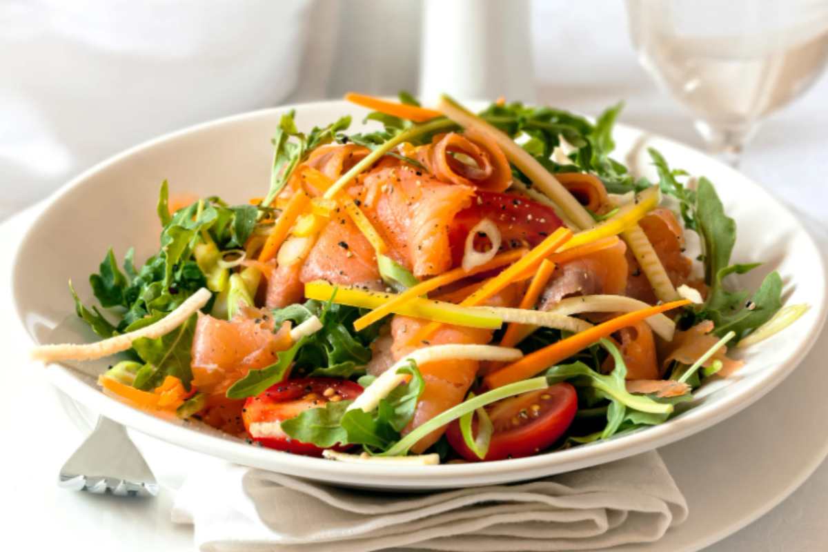 Insalata mista con carote salmone zucchine rucola e pomodori