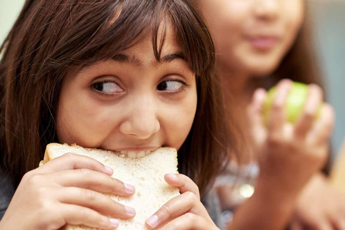 Ragazza che mangia velocemente