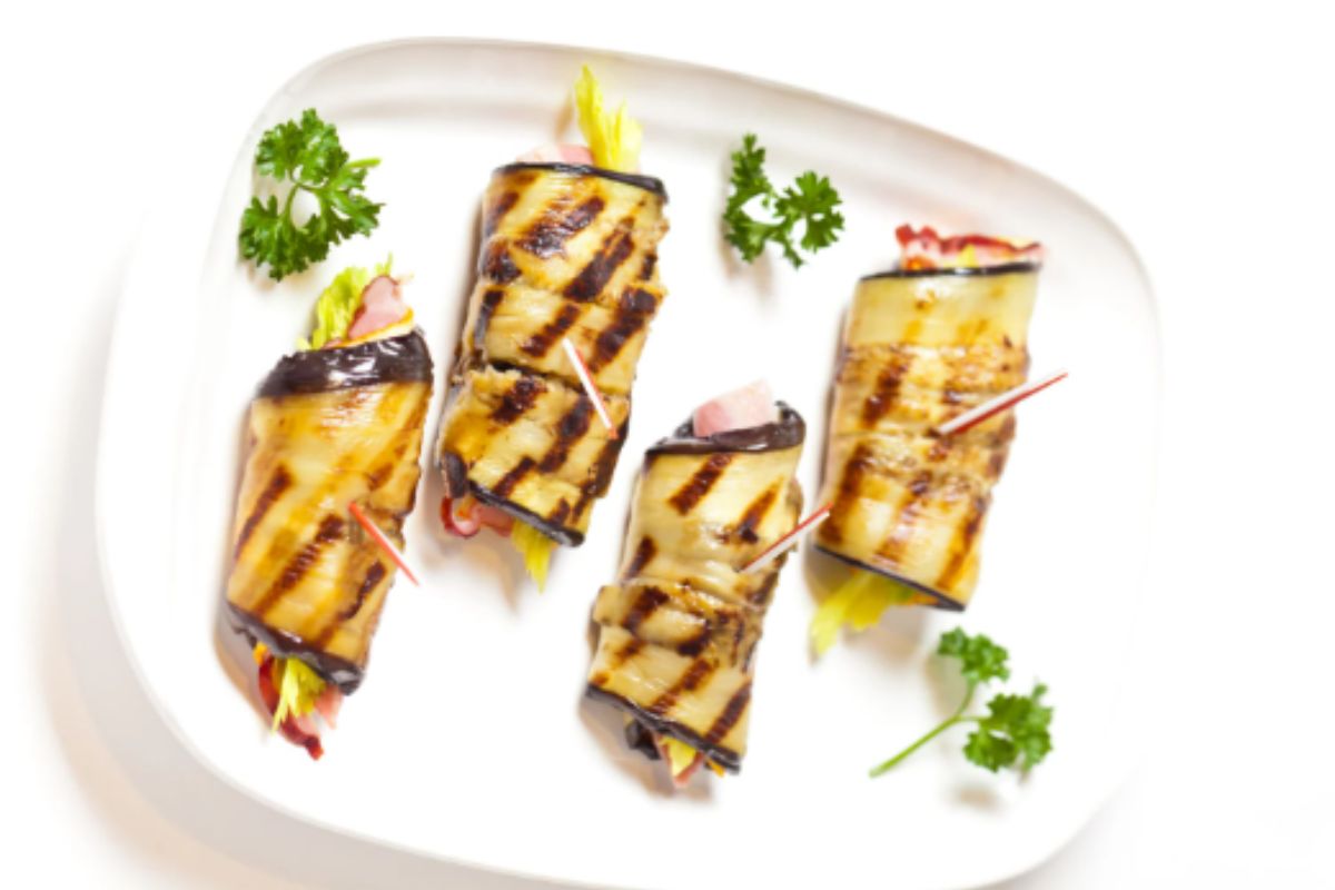 Involtini di melanzane su piatto bianco