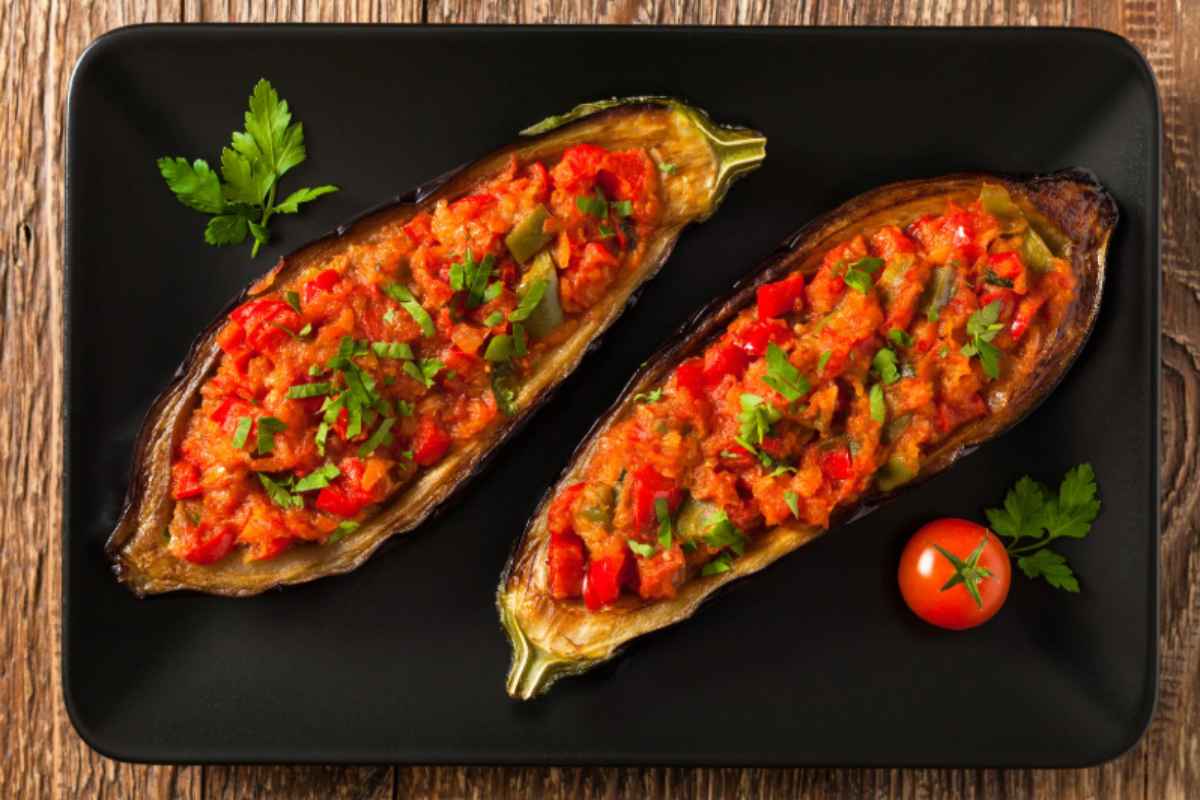 Melanzane tagliate a metà con pomodorini e basilico