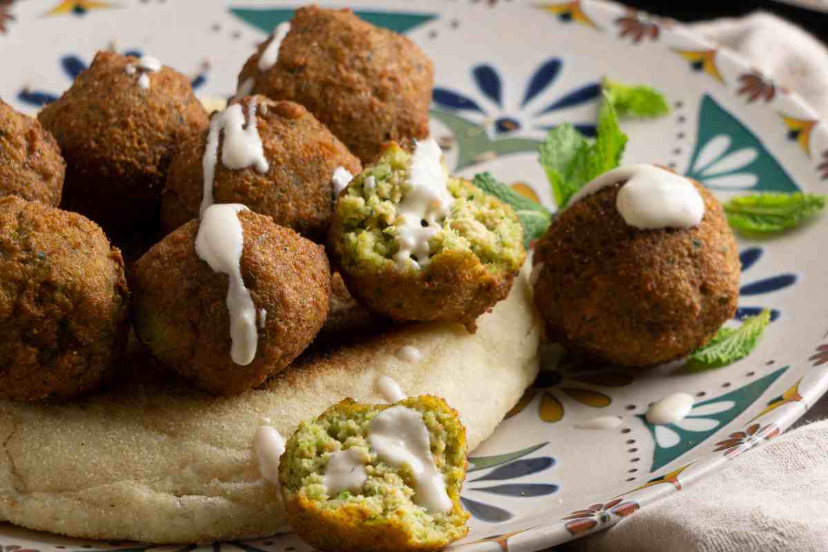 piatto con polpette di piselli su pita, decorate con salsa allo yogurt