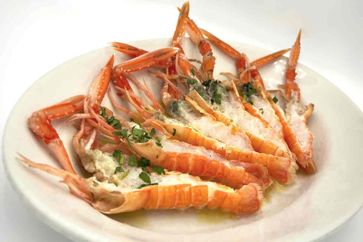 un piatto con diversi scampi crudi tagliati per essere gustati