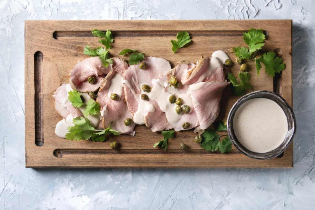 Vitello tonnato su un tagliere con salsina