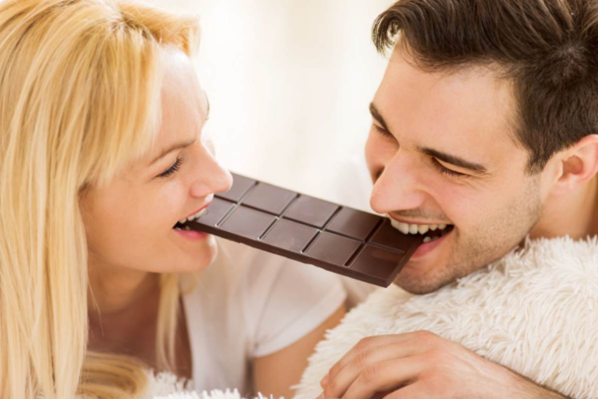 uomo e donna che mangiano una tavoletta di cioccolato