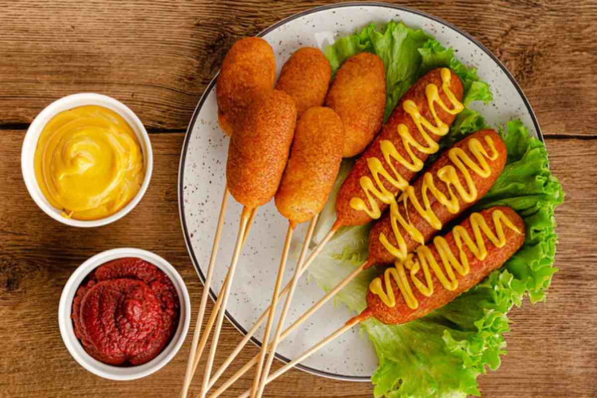 corn dog in un piatto con salse varie