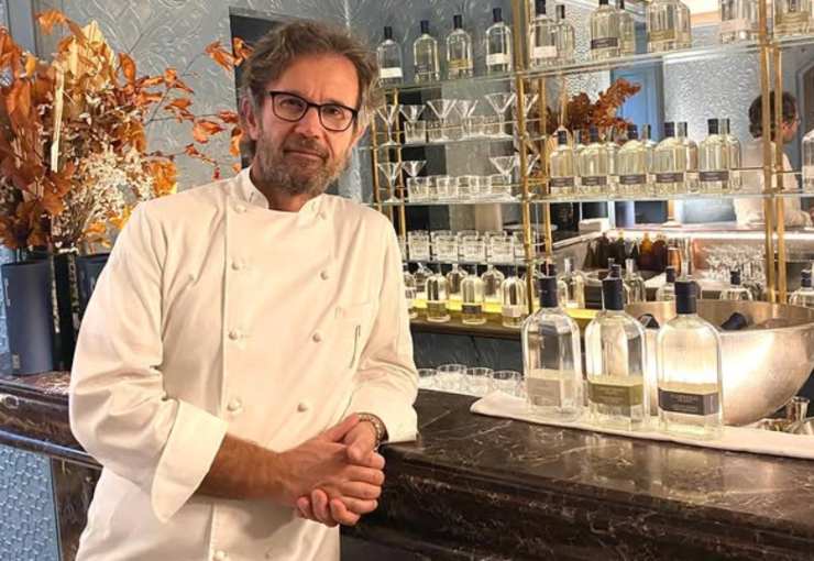 carlo cracco appoggiato al bancone del suo locale a milano