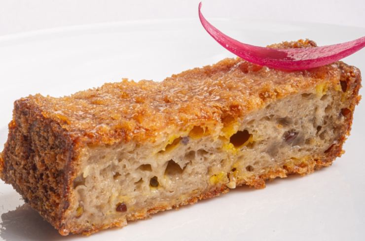 fetta di cotoletta fatta con il pane e sopra della cipolla rossa