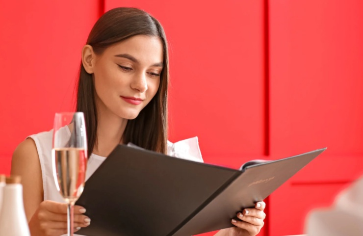 donna seduta al ristorante che legge il menù