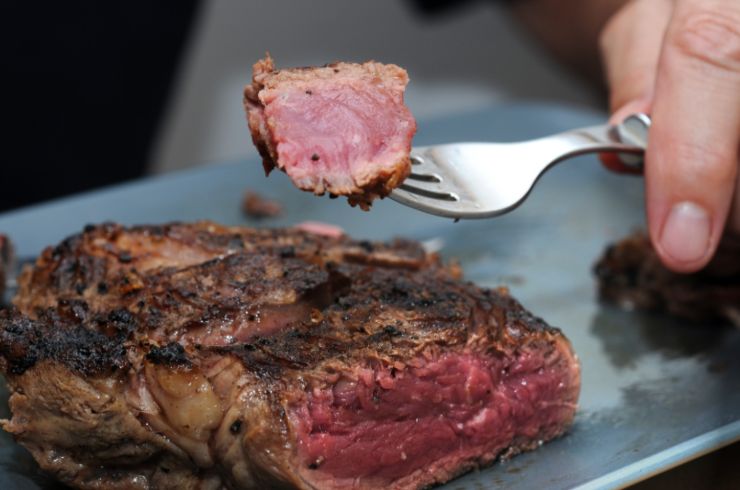 persona che mangia della carne al sangue