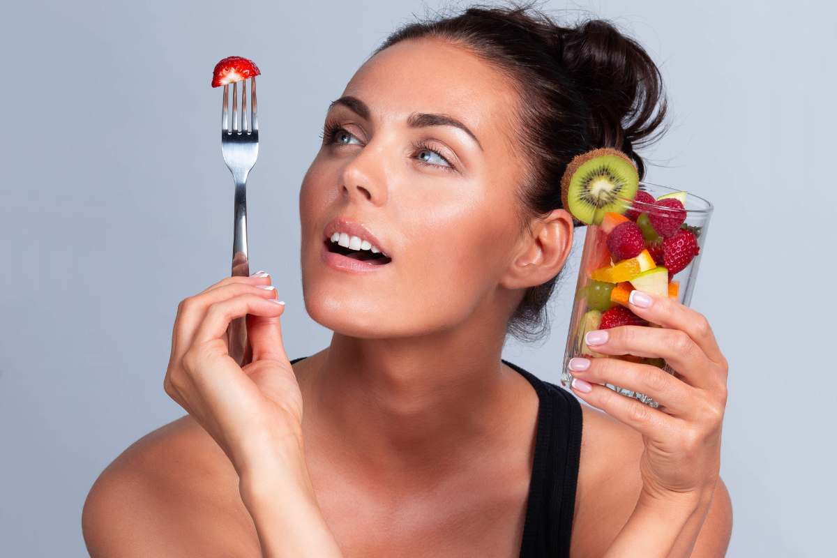 donna con bicchiere di frutta in mano
