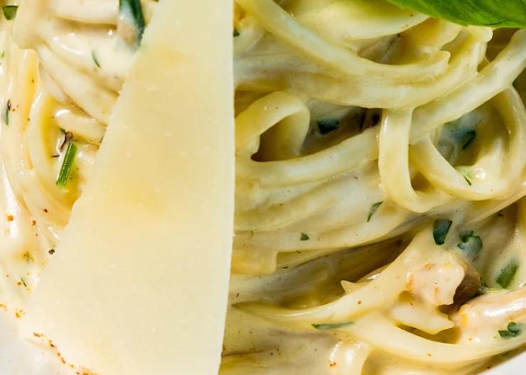 primo piano di pasta cremosa con formaggio e erbe