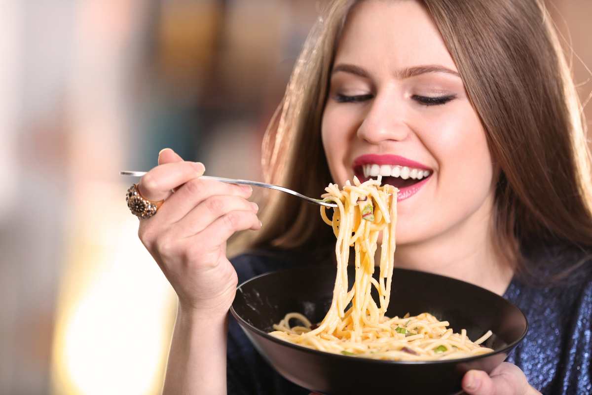 ragazza mangia un piatti di spaghetti