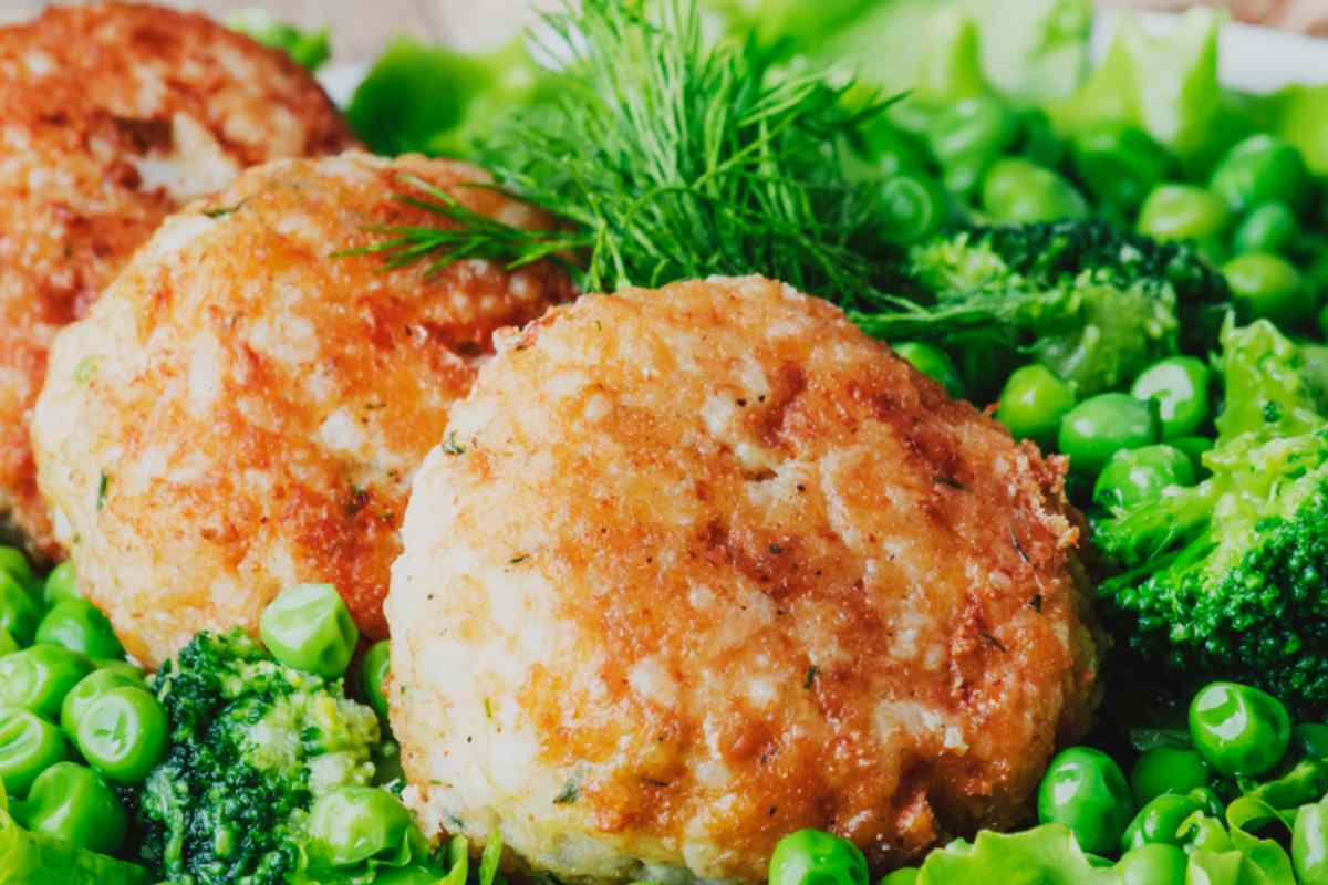 polpette di baccalà in un piatto con piselli e verdure