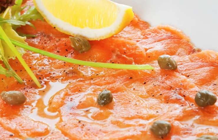 primo piano di carpaccio di salmone con limone