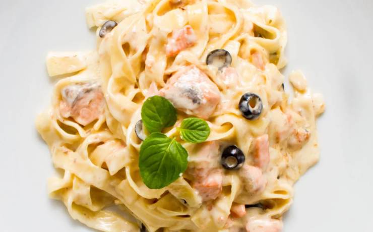 piatto di pasta cremoso con salmone e olive nere