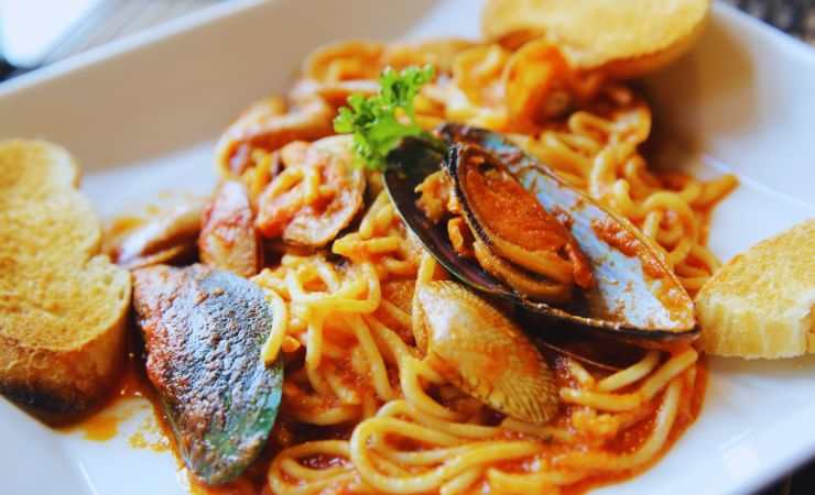 spaghetti allo scoglio con dei crostini di pane