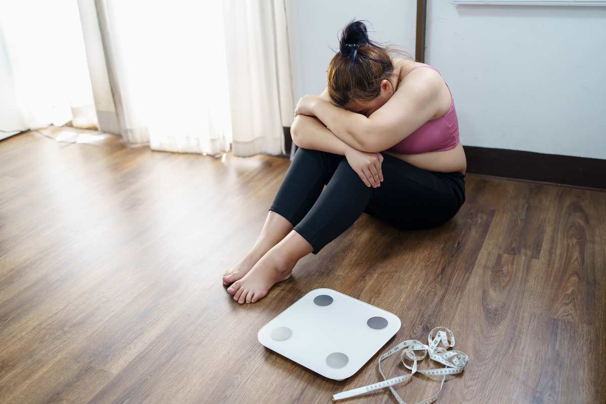 ragazza triste davanti alla bilancia