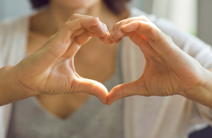 Una donna che fa la forma del cuore con le mani
