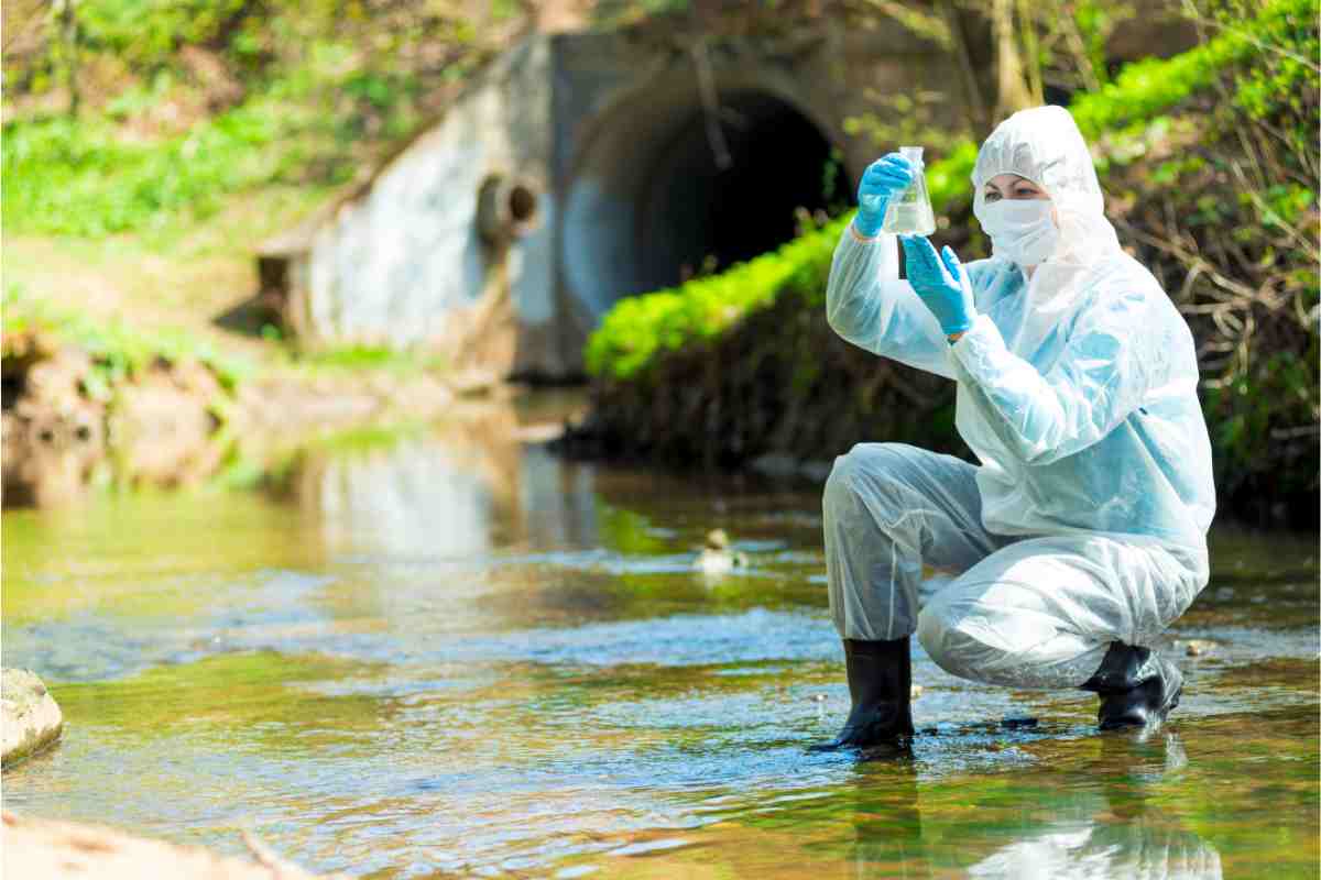 Una scienziata che raccoglie un campione di acqua da una fonte