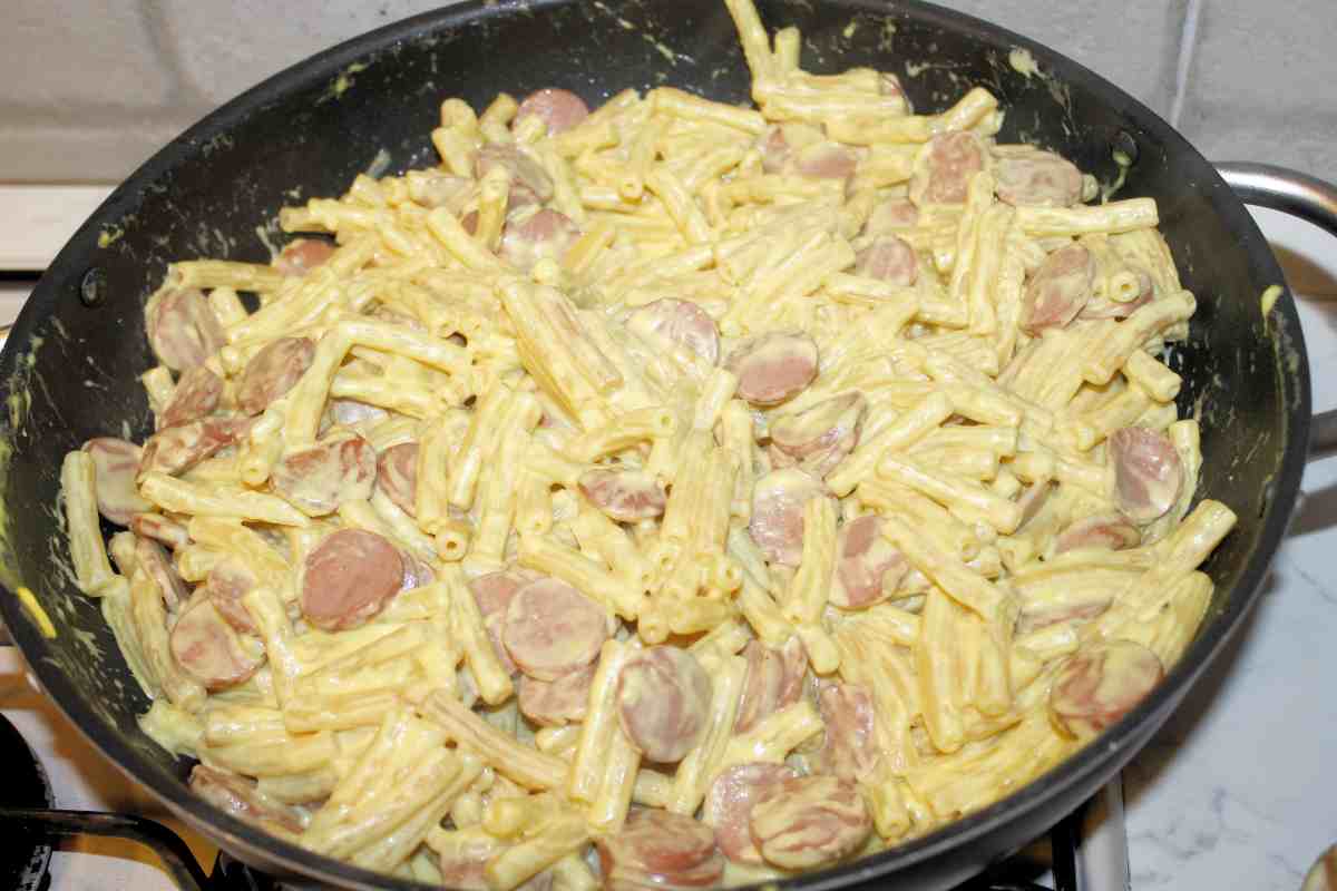 Una padella con pasta con salsicce e crema di melanzane