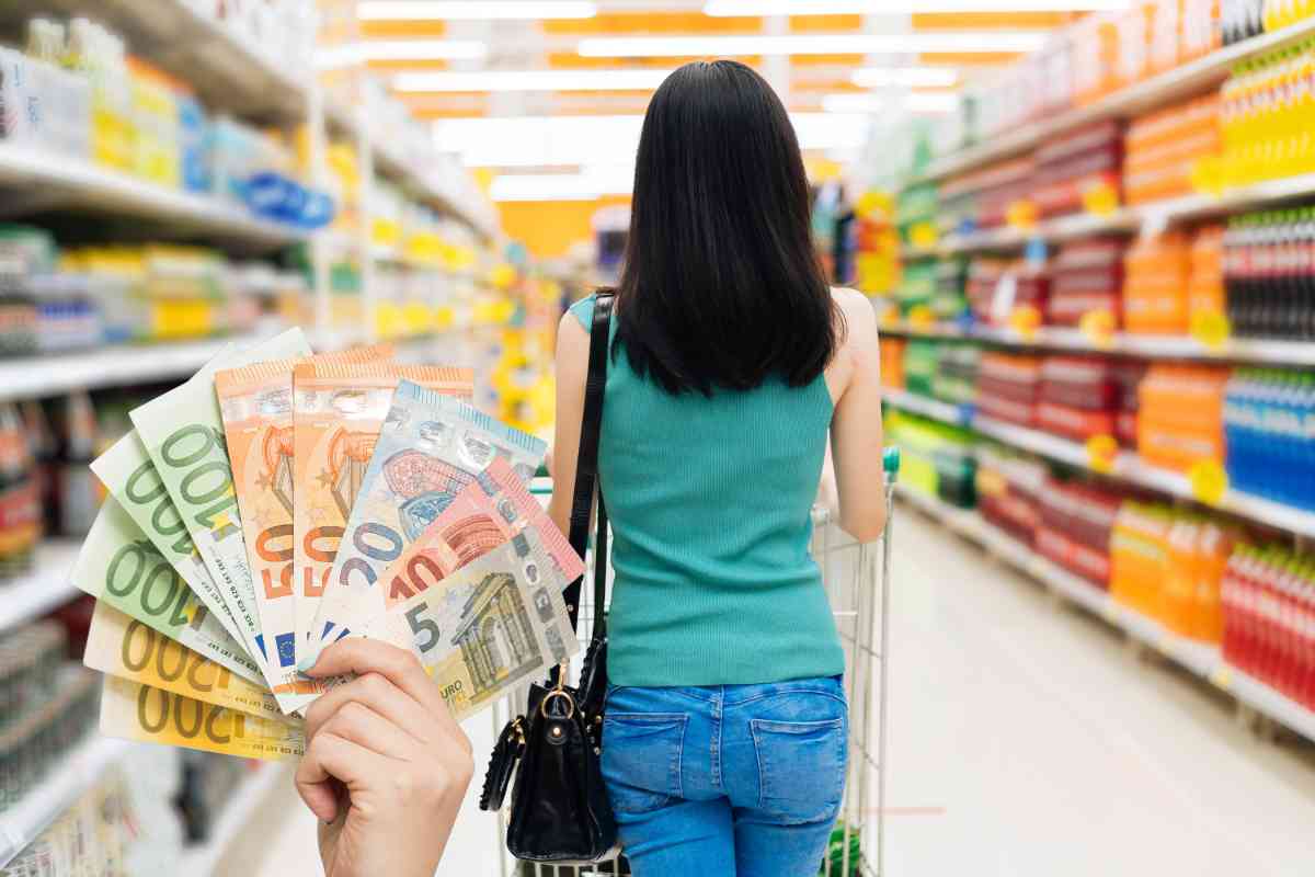 Una donna di spalle che fa la spesa al supermercato