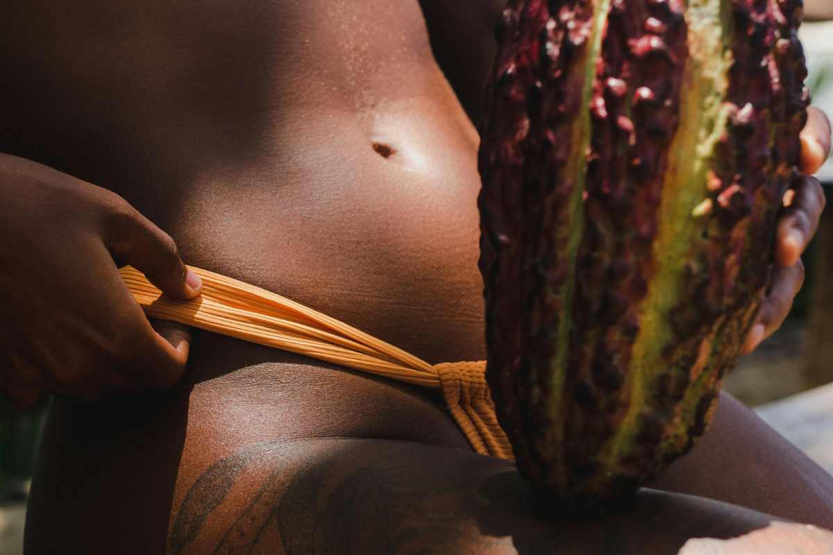 Una donna abbronzata con un frutto esotico