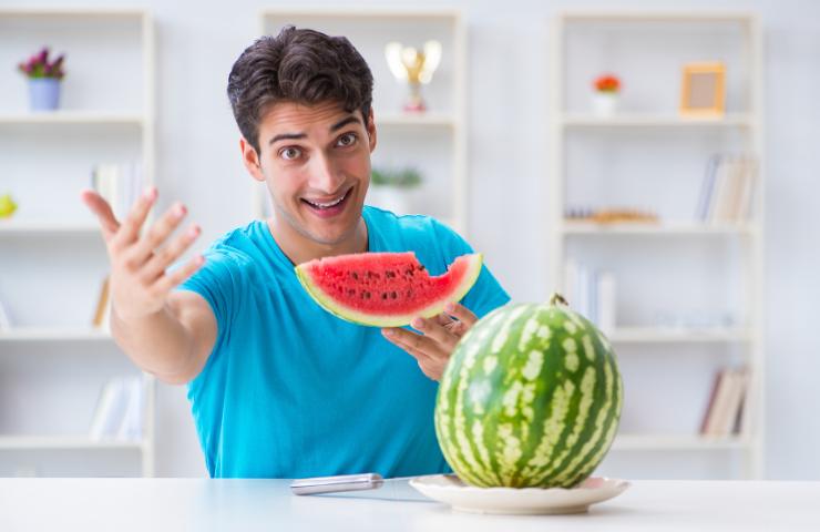 Un uomo che mangia anguria