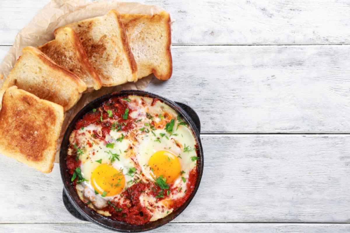 Uova al sugo in un tegame con il pane