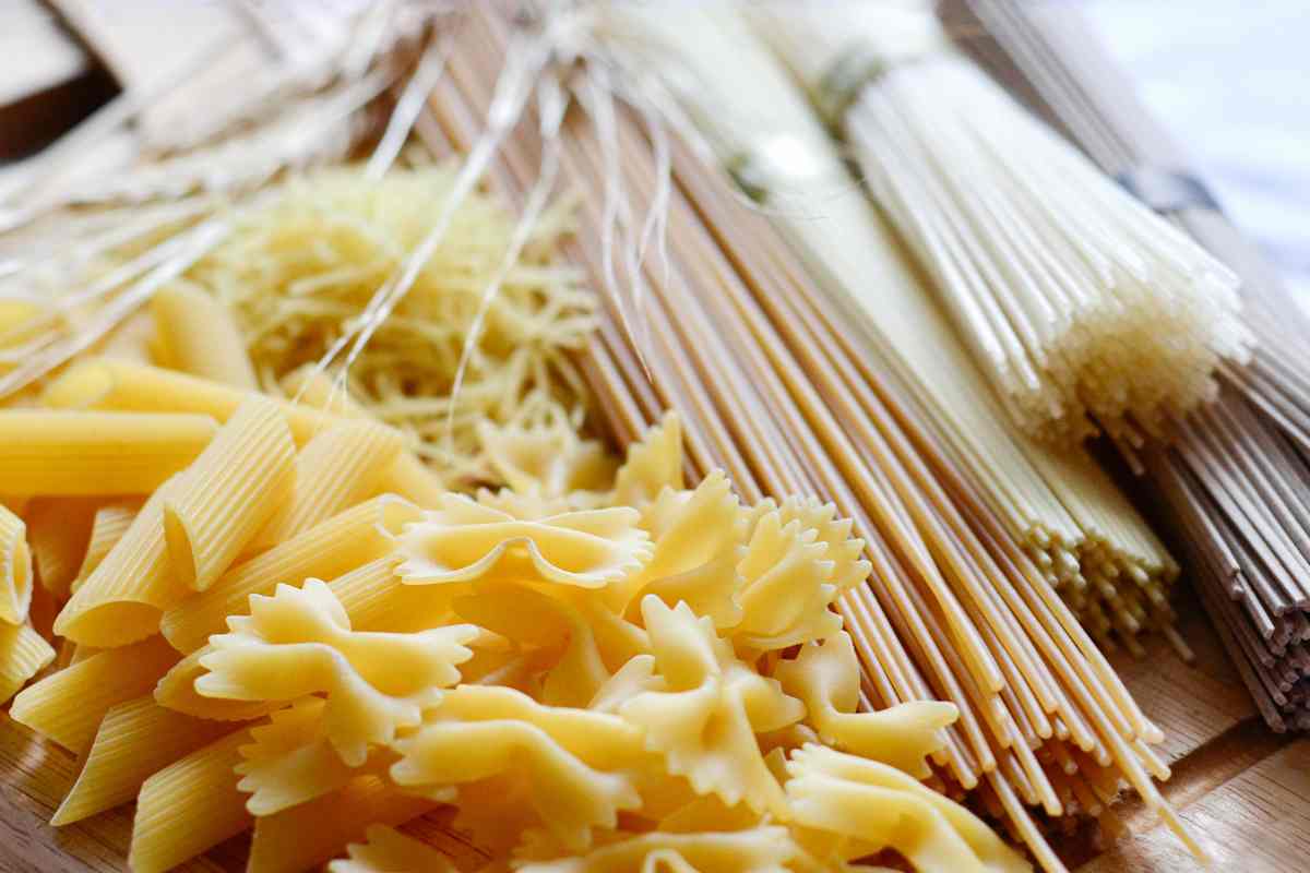 vari tipi di pasta in formato corto e lungo su un tavolo