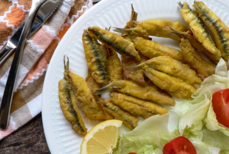 Alici fritte con insalata, limone e pomodori