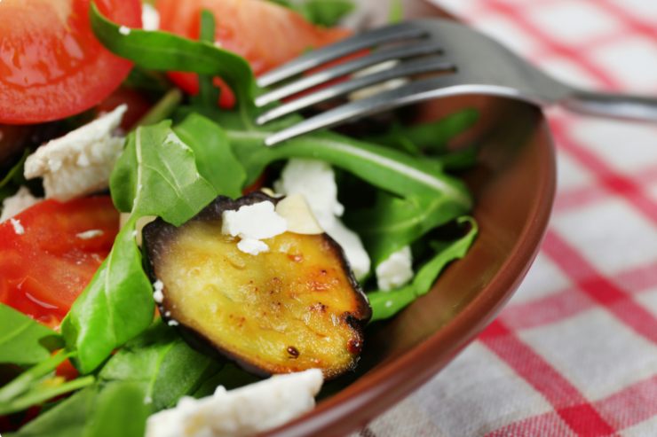 Insalata con melanzane rucola e pomodori in primo piano