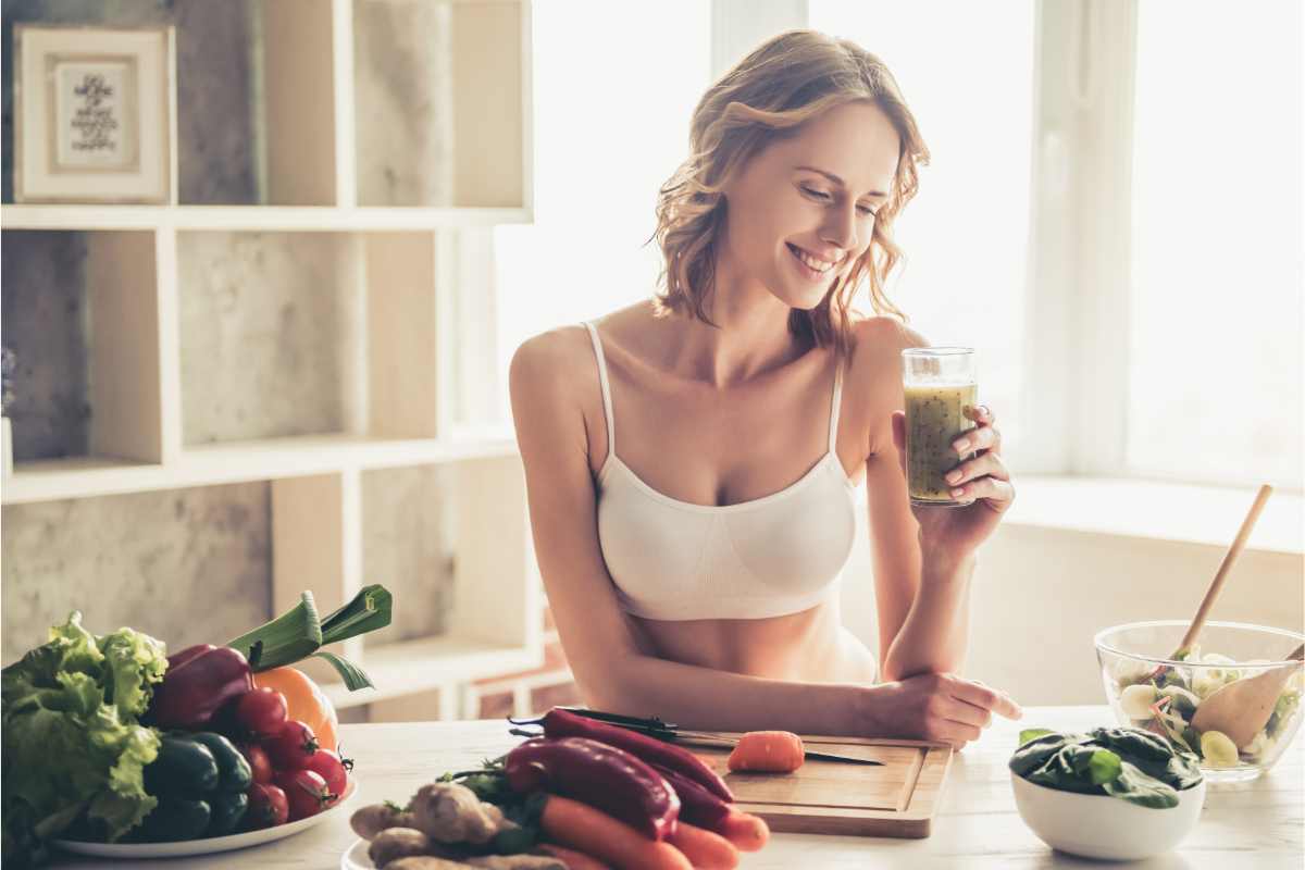Una donna in forma che beve in cucina
